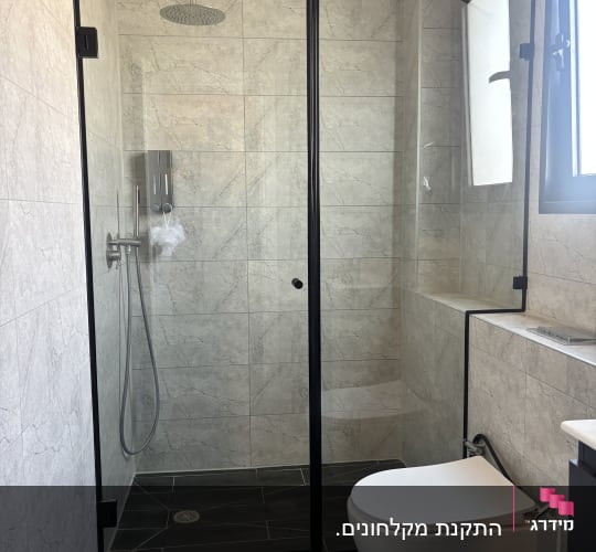 מקלחון זכוכית עם ראש מקלחת עגול ושירותים